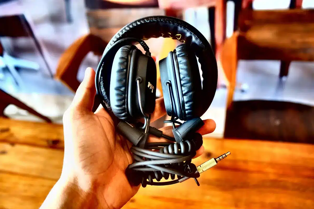 Person with headphones and playlist on phone showing algorithmic recommendations