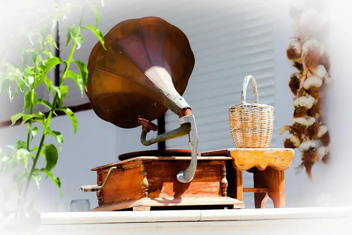 Person browsing vinyl records next to a turntable in a cozy record shop