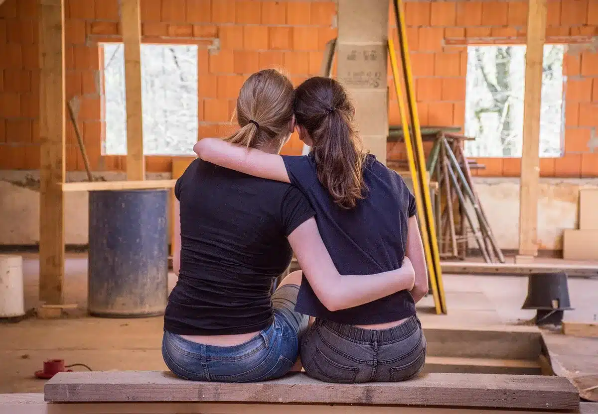 Two people embracing hesitantly in a living room